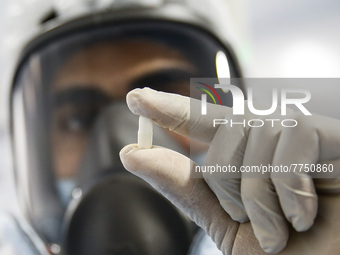 Laboratory technicians wearing full face masks and protective suits work to produce molnupiravir, the first tablet drug used to treat corona...