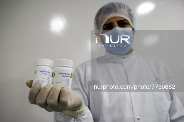 Laboratory technicians wearing full face masks and protective suits work to produce molnupiravir, the first tablet drug used to treat corona...