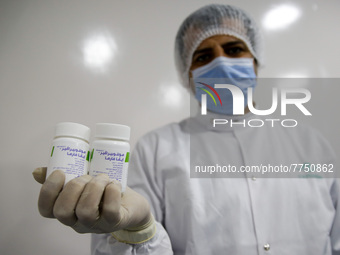 Laboratory technicians wearing full face masks and protective suits work to produce molnupiravir, the first tablet drug used to treat corona...