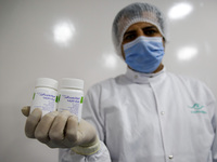 Laboratory technicians wearing full face masks and protective suits work to produce molnupiravir, the first tablet drug used to treat corona...