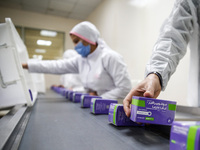 Laboratory technicians wearing full face masks and protective suits work to produce molnupiravir, the first tablet drug used to treat corona...