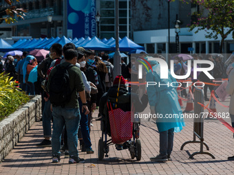 A man in wheelchair is assisted by staff  at a temporary COVID test centre in Edinburgh Place in Central Hong Kong, China, on February 11, 2...