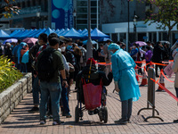 A man in wheelchair is assisted by staff  at a temporary COVID test centre in Edinburgh Place in Central Hong Kong, China, on February 11, 2...