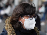 A woman wearing a face masks walks in Santa Cruz de Tenerife on 13 February 2022 (