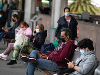 People wait at a bust stop in Santa Cruz de Tenerife on 13 February 2022. (