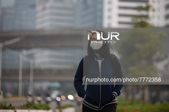 Woman wear protective face masks walk in business district in Jakarta on February 14, 2022. The Minister of Manpower, Ida Fauziyah, stipulat...