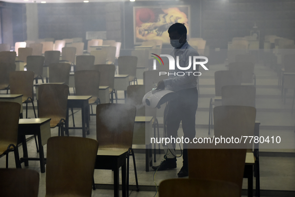 A man sanitises a primary school before it re-opens as the school close due to coronavirus surge in Kolkata, India, 15 February, 2022.  