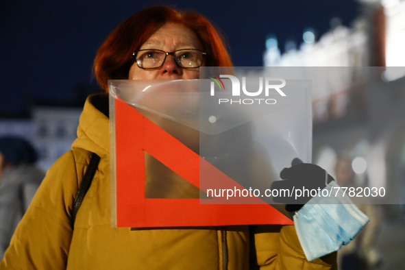 A woman holds a red set square banner while demonstrating during 'Stop Lex Czarnek' protest at the Main Square in Krakow, Poland on February...