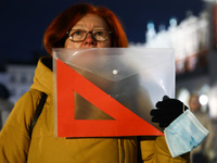 A woman holds a red set square banner while demonstrating during 'Stop Lex Czarnek' protest at the Main Square in Krakow, Poland on February...