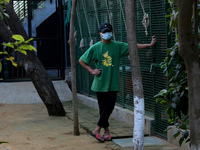 A caretaker stands outside an enclosure for cats at a rescue center acting as home for elderly, abandoned and rescued felines, on the occasi...