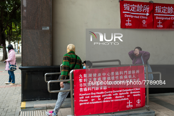 COVID patients and their helper exit the Kowloon Bay Health Centre. This Centre was established as a one of the designated clinics for COVID...