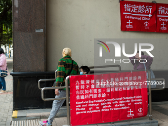 COVID patients and their helper exit the Kowloon Bay Health Centre. This Centre was established as a one of the designated clinics for COVID...