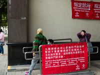 COVID patients and their helper exit the Kowloon Bay Health Centre. This Centre was established as a one of the designated clinics for COVID...