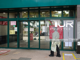 Healthcare staff in full PPE enters the Kowloon Bay Health Centre. This Centre was established as a one of the designated clinics for COVID...