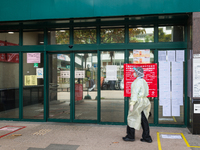 Healthcare staff in full PPE enters the Kowloon Bay Health Centre. This Centre was established as a one of the designated clinics for COVID...