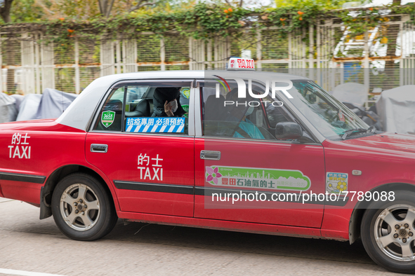 A specially designated taxi (the blue logo on the back window distinguishes them) brings a COVID patient to the Kowloon Bay Health Centre. T...