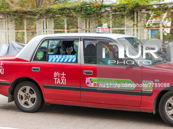 A specially designated taxi (the blue logo on the back window distinguishes them) brings a COVID patient to the Kowloon Bay Health Centre. T...