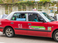 A specially designated taxi (the blue logo on the back window distinguishes them) brings a COVID patient to the Kowloon Bay Health Centre. T...