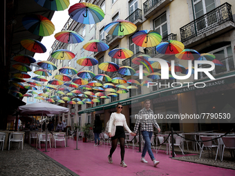 People walk on a street in Lisbon, Portugal, on February 18, 2022. Portuguese Government announced Thursday it is winding down its coronavir...