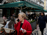 People walk by the A Brasileira cafe in the Chiado neighborhood in Lisbon, Portugal, on February 18, 2022. Portuguese Government announced T...