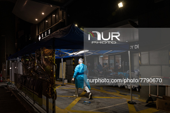 A patient lies in a hospital bed waiting for medical treatment in a temporary holding area outside Caritas Medical Center in Hong Kong, Chin...