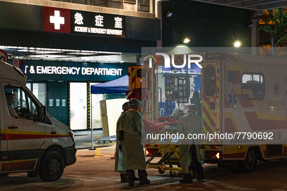 A patient lies in a hospital bed waiting for medical treatment in a temporary holding area outside Caritas Medical Center in Hong Kong, Chin...