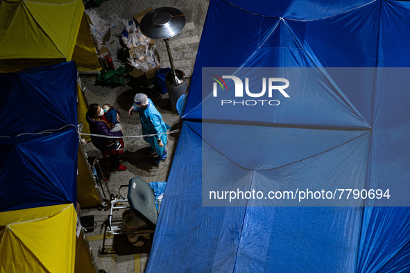 A patient lies in a hospital bed waiting for medical treatment in a temporary holding area outside Caritas Medical Center in Hong Kong, Chin...