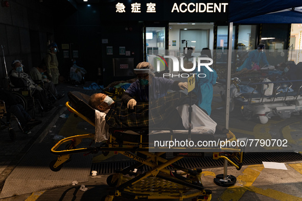 A patient lies in a hospital bed waiting for medical treatment in a temporary holding area outside Caritas Medical Center in Hong Kong, Chin...