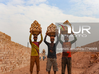 Workers poses for a photograph at a brickyard in Dhaka Bangladesh on February 20, 2022.(