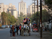 Men ride a horse cart used in wedding ceremonies to carry brides and grooms, at  a residential neighbourhood in Ghaziabad, on the outskirts...