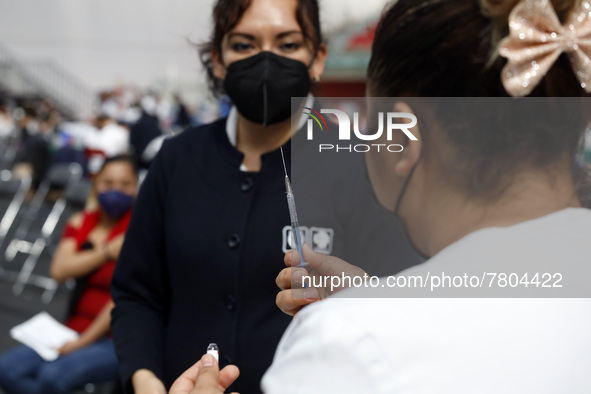 A nurse prepares a Sputnik-V dose booster  to supply it to a person inside Sport City facilities, during the mass vaccination campaign for c...