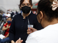 A nurse prepares a Sputnik-V dose booster  to supply it to a person inside Sport City facilities, during the mass vaccination campaign for c...