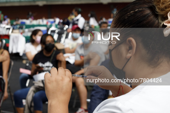 A nurse prepares a Sputnik-V dose booster  to supply it to a person inside Sport City facilities, during the mass vaccination campaign for c...