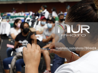 A nurse prepares a Sputnik-V dose booster  to supply it to a person inside Sport City facilities, during the mass vaccination campaign for c...