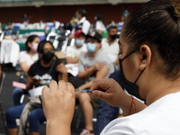 A nurse prepares a Sputnik-V dose booster  to supply it to a person inside Sport City facilities, during the mass vaccination campaign for c...