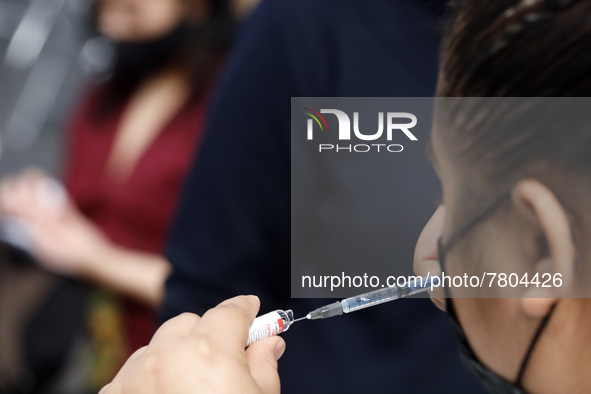 A nurse prepares a Sputnik-V dose booster  to supply it to a person inside Sport City facilities, during the mass vaccination campaign for c...