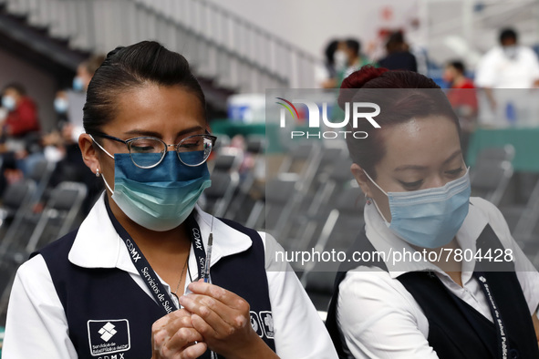 A nurse prepares a Sputnik-V dose booster  to supply it to a person inside Sport City facilities, during the mass vaccination campaign for c...