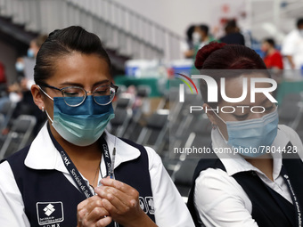 A nurse prepares a Sputnik-V dose booster  to supply it to a person inside Sport City facilities, during the mass vaccination campaign for c...