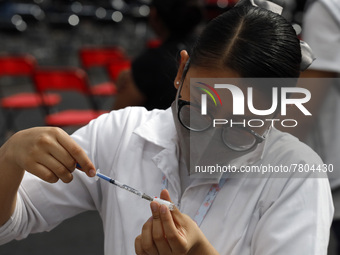 A nurse prepares a Sputnik-V dose booster  to supply it to a person inside Sport City facilities, during the mass vaccination campaign for c...