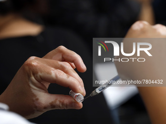 A nurse prepares a Sputnik-V dose booster  to supply it to a person inside Sport City facilities, during the mass vaccination campaign for c...