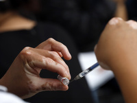 A nurse prepares a Sputnik-V dose booster  to supply it to a person inside Sport City facilities, during the mass vaccination campaign for c...