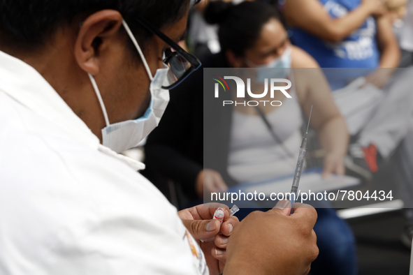 A male nurse prepares a Sputnik-V dose booster  to supply it to a person inside Sport City facilities, during the mass vaccination campaign...