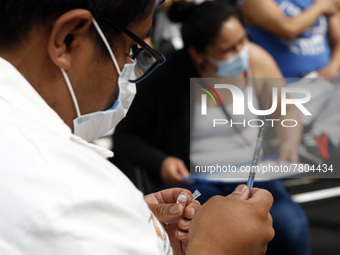 A male nurse prepares a Sputnik-V dose booster  to supply it to a person inside Sport City facilities, during the mass vaccination campaign...