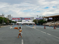 A child plays near an almost empty drive-thru vaccination site in Manila City, Philippines on February 23, 2022. Metro Manila mayors urged t...