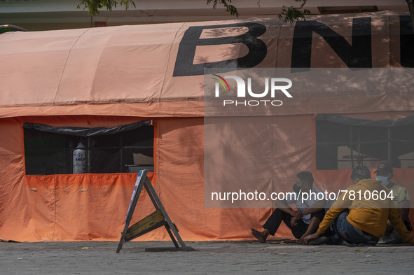 Residents wait for their families who are being treated for COVID-19 in emergency tents set up at Undata Hospital, Palu, Central Sulawesi Pr...