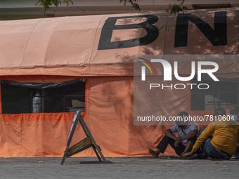 Residents wait for their families who are being treated for COVID-19 in emergency tents set up at Undata Hospital, Palu, Central Sulawesi Pr...