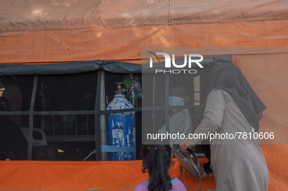 Residents visit their families who are being treated for COVID-19 in an emergency tent set up at Undata Hospital, Palu, Central Sulawesi Pro...