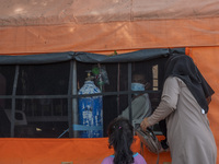 Residents visit their families who are being treated for COVID-19 in an emergency tent set up at Undata Hospital, Palu, Central Sulawesi Pro...