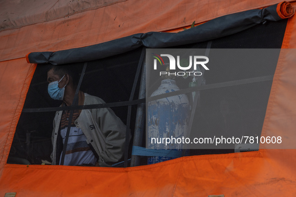 A patient looks out of the window of an emergency tent where the COVID-19 treatment was set up at Undata Hospital, Palu, Central Sulawesi Pr...