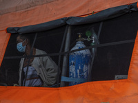 A patient looks out of the window of an emergency tent where the COVID-19 treatment was set up at Undata Hospital, Palu, Central Sulawesi Pr...